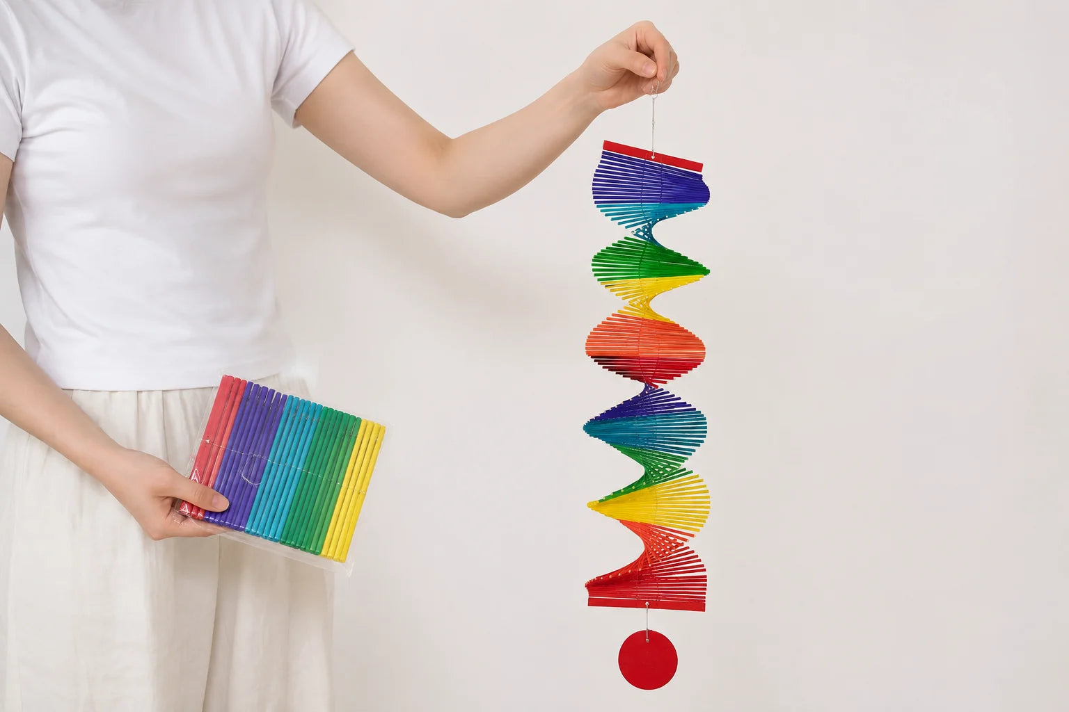 Handwoven boho rainbow macramé wall hanging with decorative bell displayed in a cozy modern home